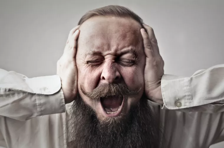 Photo of a man holding the sides of his head